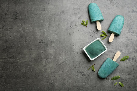 Flat lay composition with delicious spirulina icecream and powder on gray background. Space for textの写真素材