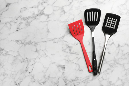 Clean spatulas on marble background, flat lay. Space for textの写真素材