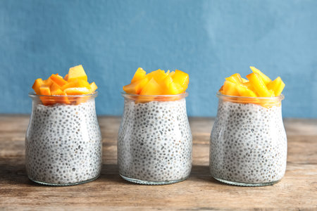 Jars of tasty chia seed pudding with persimmon on tableの写真素材