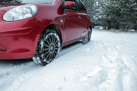 Modern car on snowy road in winter forest. Space for textの写真素材