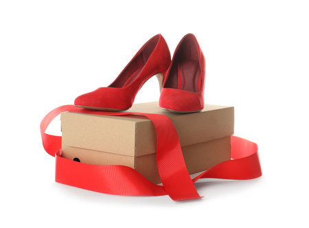 Pair of stylish high heel shoes and cardboard box on white backgroundの写真素材