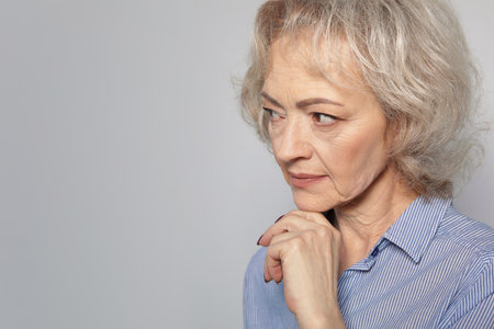 Portrait of mature woman on gray background. Space for textの写真素材