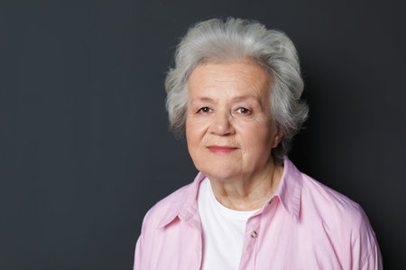 Portrait of mature woman on black background. Space for textの写真素材