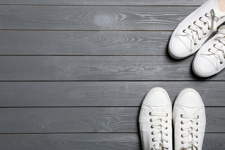 White sneakers and space for text on wooden background, top view. Stylish shoesの写真素材