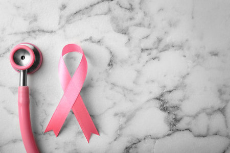 Pink ribbon and stethoscope on marble background, top view with space for text. breast cancer conceptの写真素材