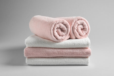 Stack of fresh towels on light backgroundの写真素材