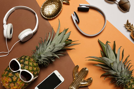 Flat lay composition with pineapples, headphones and smart phone on color backgroundの写真素材