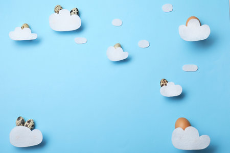 Flat lay composition of felt clouds and Easter eggs on color background, space for textの写真素材