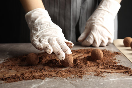 Woman preparing tasty chocolate truffles at table, closeupの写真素材