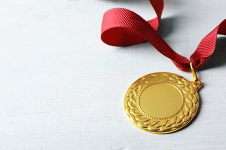 Gold medal with space for design on white wooden background. Victory conceptの写真素材