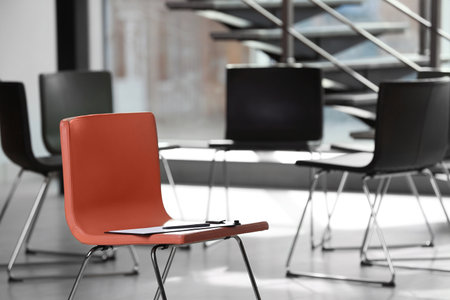 Red chair with clipboard in office prepared for group therapy. meeting room interiorの写真素材