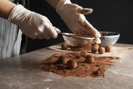 Woman preparing tasty chocolate truffles at table, closeupの写真素材