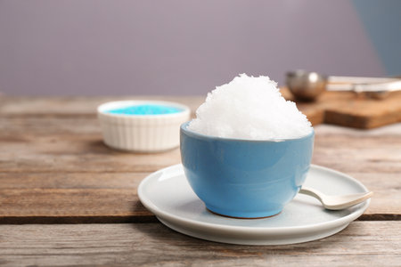 Bowl of tasty snow ice cream on wooden table. Space for textの写真素材