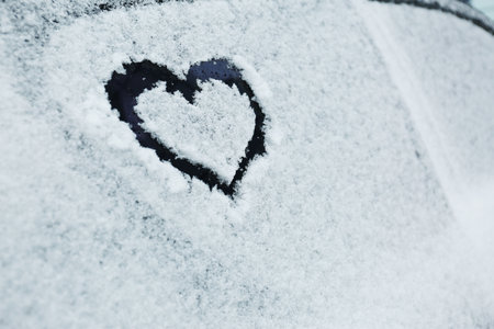 Heart drawn on car covered with snow, closeup. Space for textの写真素材