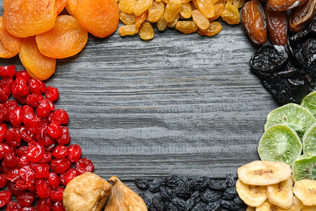 Frame made of different dried fruits on wooden background, flat lay with space for text. healthy lifestyleの写真素材