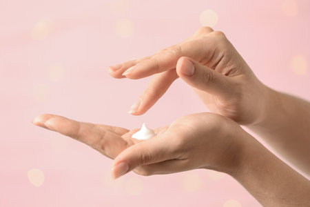 Woman applying hand cream on blurred background, closeupの写真素材