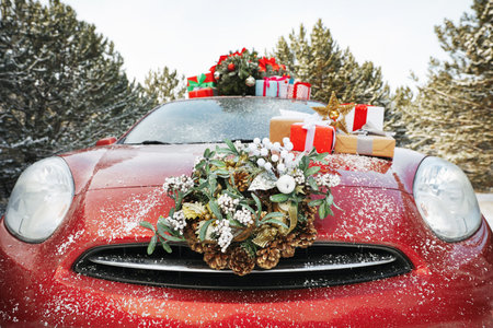 Car with Christmas wreath, tree and gifts in winter forest, closeupの写真素材