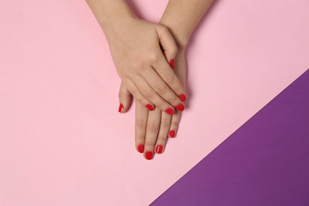 Woman showing red manicure on color background, top view. Nail polish trendsの写真素材
