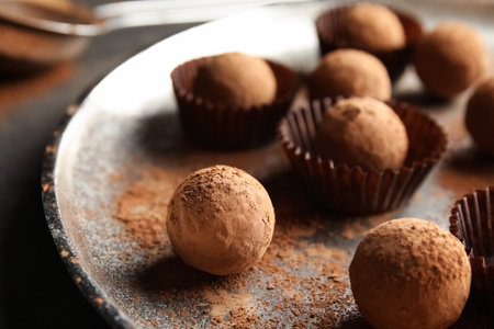 Plate with tasty chocolate truffles on gray table, closeup
