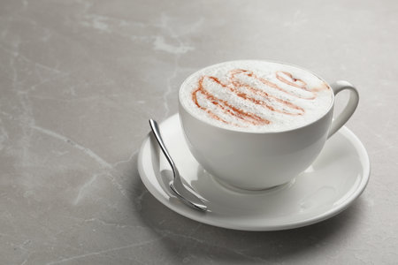 Cup of tasty caramel macchiato on table. Space for textの写真素材