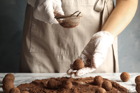 Woman preparing tasty chocolate truffles at table, closeupの写真素材