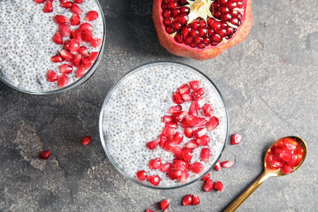 Tasty chia seed pudding with pomegranate served on table, flat layの写真素材