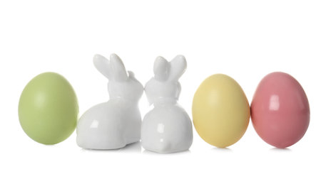 Cute ceramic Easter bunnies and dyed eggs on white backgroundの写真素材