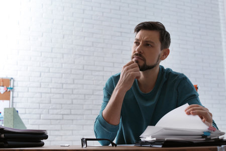 Man working with documents at table in office. Space for text