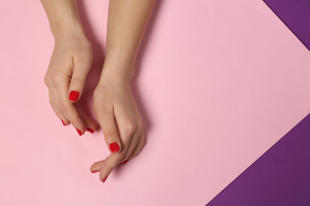 Woman showing red manicure on color background, top view with space for text. Nail polish trendsの写真素材