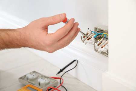 Electrician with neon-lamp tester checking voltage indoors, closeupの写真素材