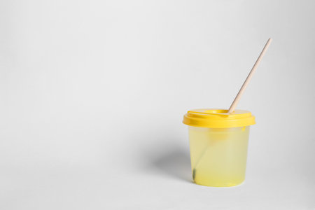Paint brush in cup of water on light background. Space for textの写真素材