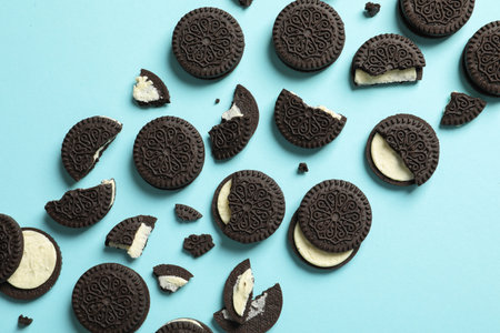 Tasty chocolate cookies with cream on color background, flat layの写真素材