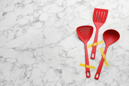 Different clean kitchen utensils on marble background, flat lay. Space for textの写真素材