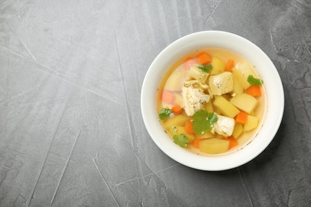 Homemade chicken soup in dish on gray background, top view with space for textの写真素材