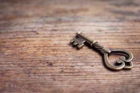Old vintage key on wooden background, space for textの写真素材