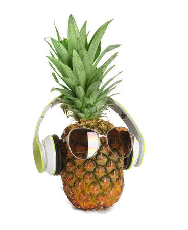 Funny pineapple with headphones and sunglasses on white backgroundの写真素材