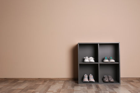 Modern cabinets with different sneakers near color wall, space for textの写真素材