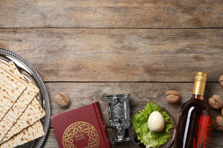 Flat lay composition with symbolic Passover (Pesach) items on wooden background, space for text