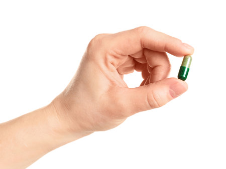 Woman holding spirulina pill on white background, closeupの写真素材