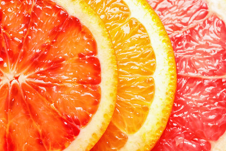 Slices of fresh citrus fruits as background, top viewの写真素材
