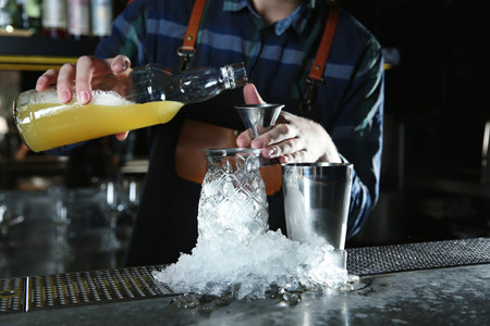 Barman making tropical cocktail at counter in pub, closeupの写真素材