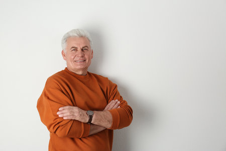 Portrait of handsome mature man on light background. Space for textの写真素材