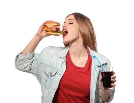 Pretty woman with tasty burger and cola isolated on whiteの写真素材