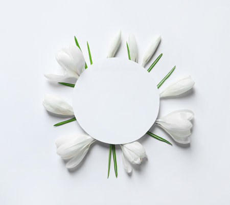 Beautiful spring crocus flowers and card on white background, top view. Space for textの写真素材