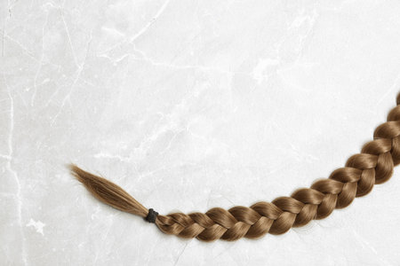 Braided hair on gray background, top view with space for textの写真素材