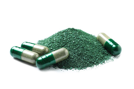 Pile of spirulina powder and pills on white backgroundの写真素材