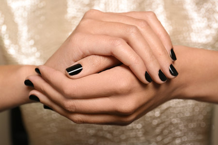 Woman in gold dress with black manicure, closeup. Nail polish trendsの写真素材