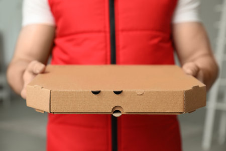 Man with pizza box indoors, closeup. food delivery serviceの写真素材