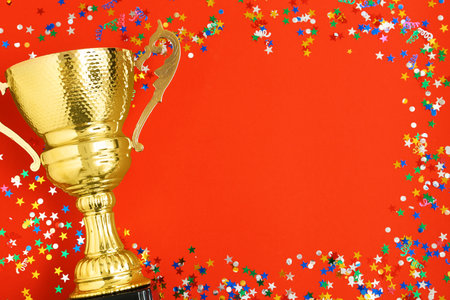 Trophy and frame of confetti on color background, top view with space for text. Victory conceptの写真素材