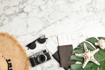 Flat lay composition with tourist items and camera on marble background, space for text. travel agencyの写真素材
